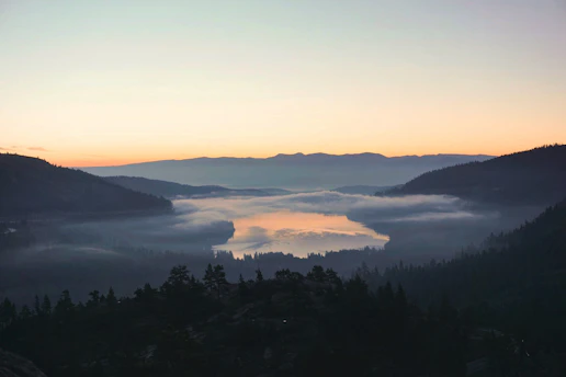 A vibrant sunrise over a serene mountain lake, perfect for a peaceful travel moment.