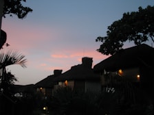 Evening view of huts illuminated by soft lantern light along the beach path.
