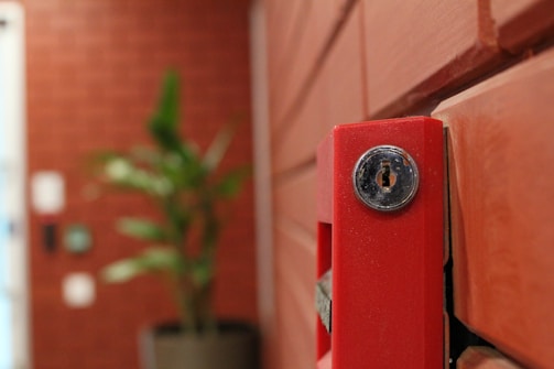 A technician carefully installs a fire alarm system in a modern office building.