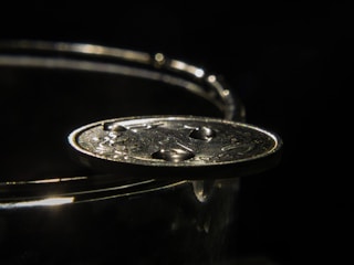 Close-up of a sleek felitwo coin glowing softly against a dark background.