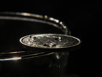 Close-up of a gleaming certified anime-themed coin resting on a black velvet cushion under soft spotlight.