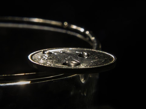 Close-up of a sleek felitwo coin glowing softly against a dark background.