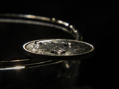 Close-up of a glowing humi coin with neon accents resting on a sleek black surface.