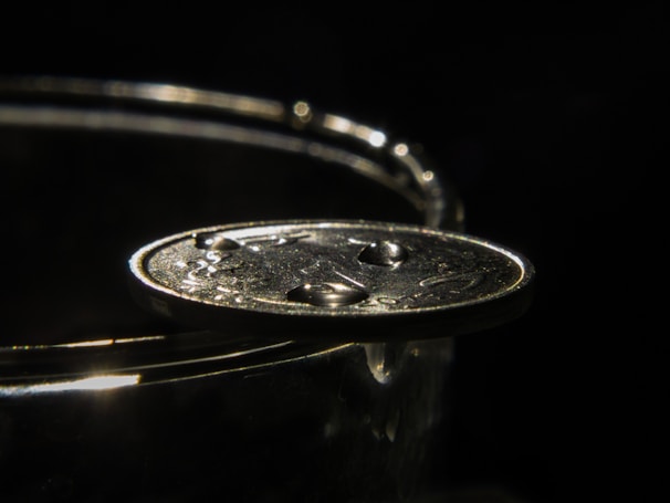 Close-up of a gleaming certified anime-themed coin resting on a black velvet cushion under soft spotlight.
