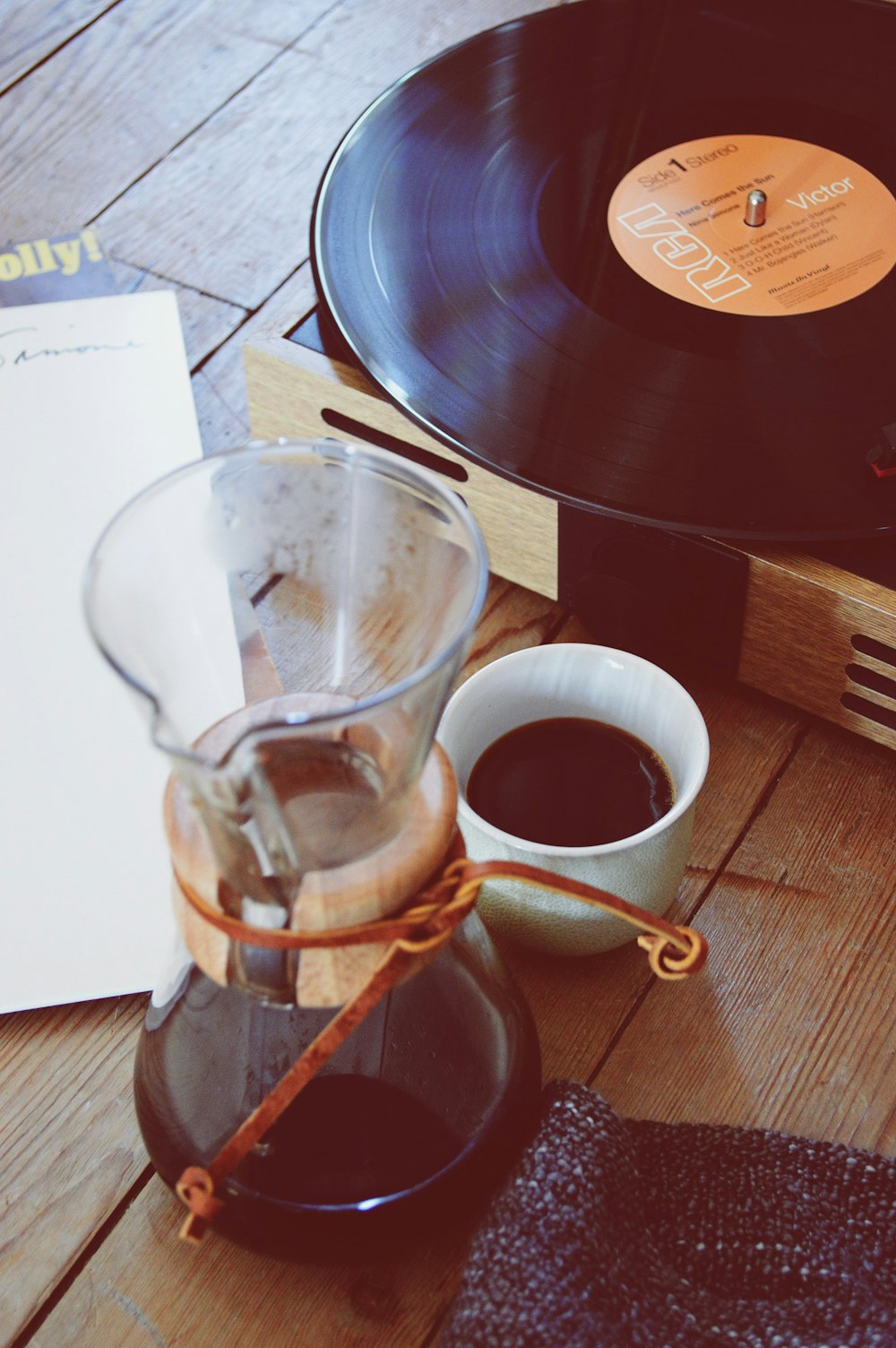 clear glass coffee pitcher beside turntable