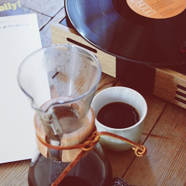 clear glass coffee pitcher beside turntable