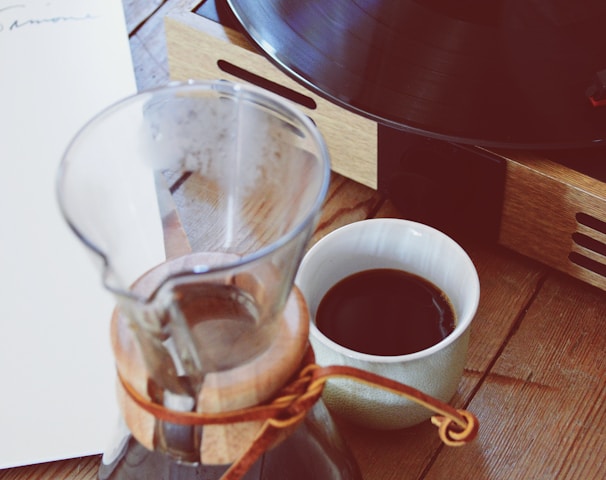 clear glass coffee pitcher beside turntable