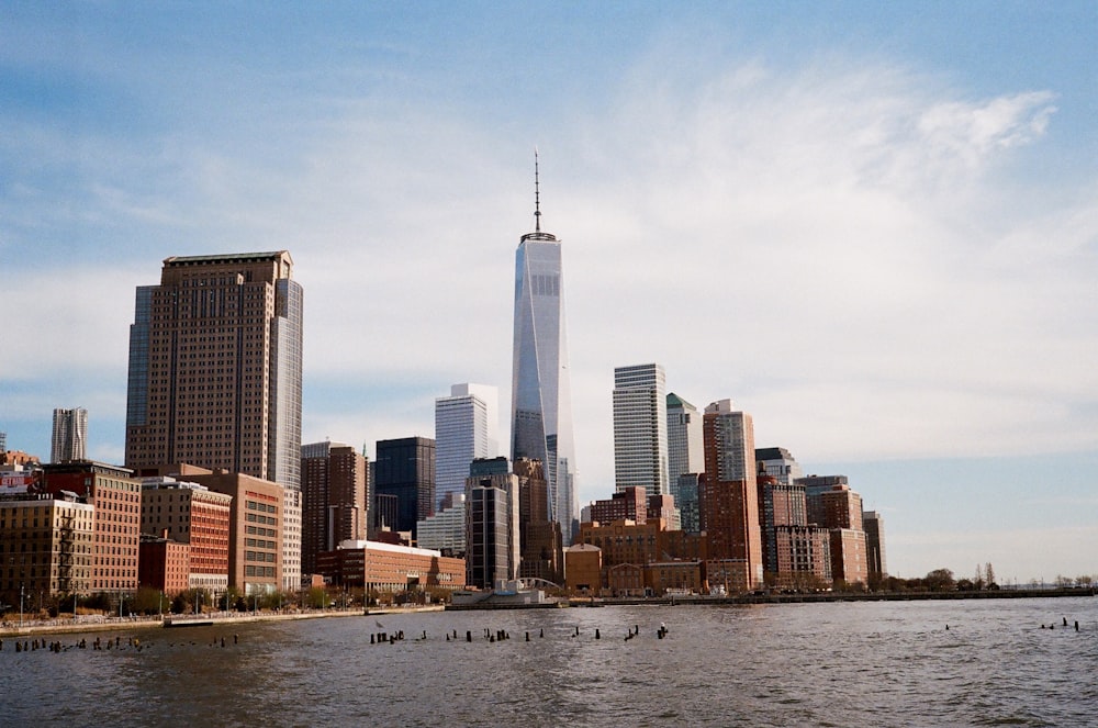 city near body of water under white and blue sky during daytime photgraphy