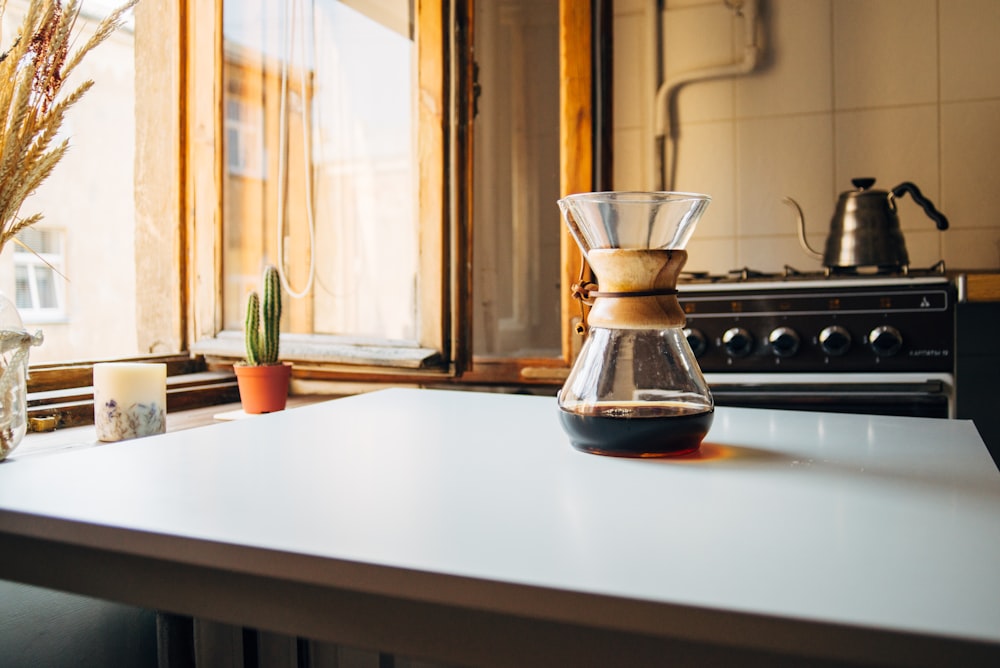 fast leere schwarze Flüssigkeit im Glas auf weißem Tisch