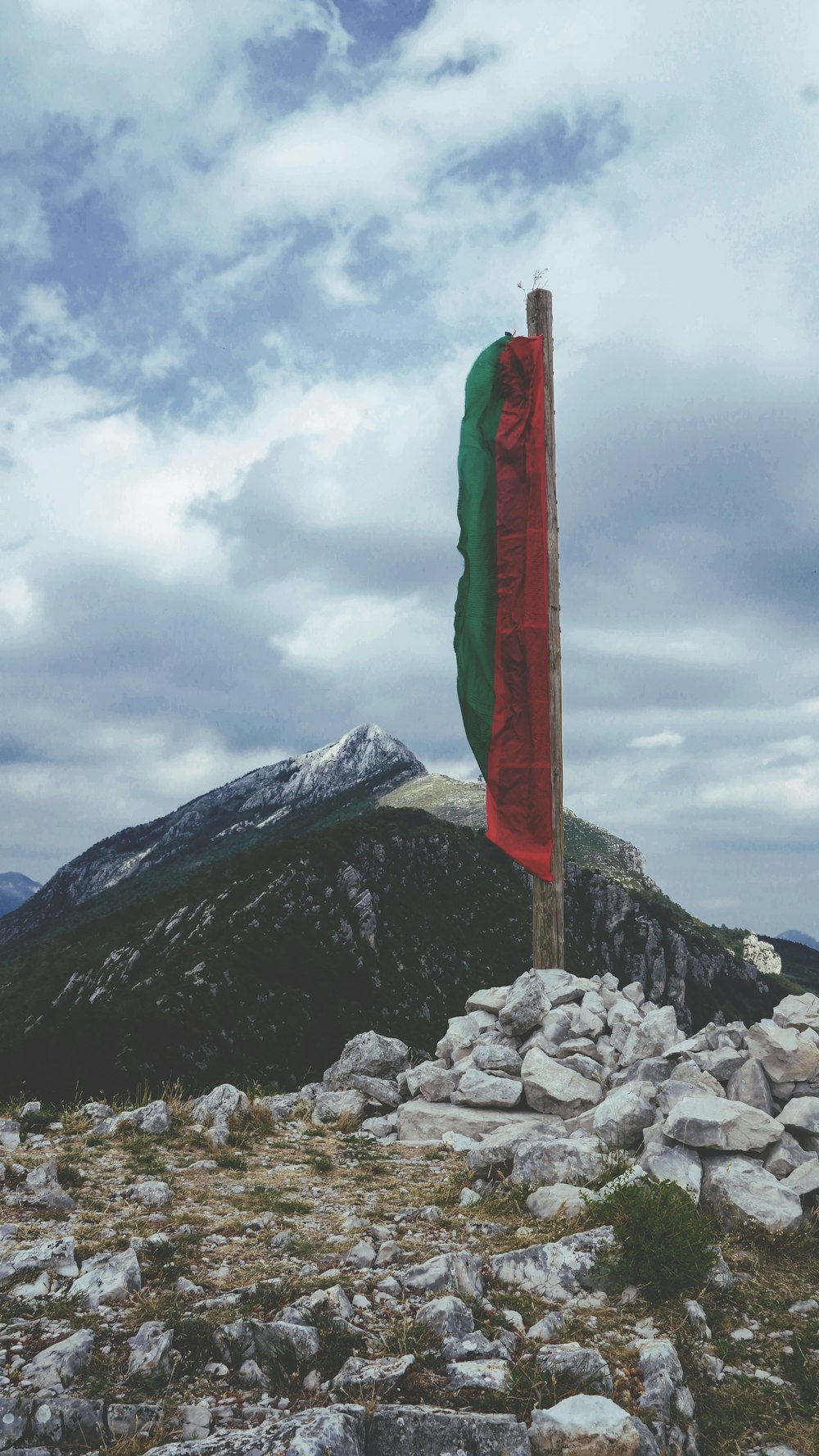 green and red flag on pile of rocks