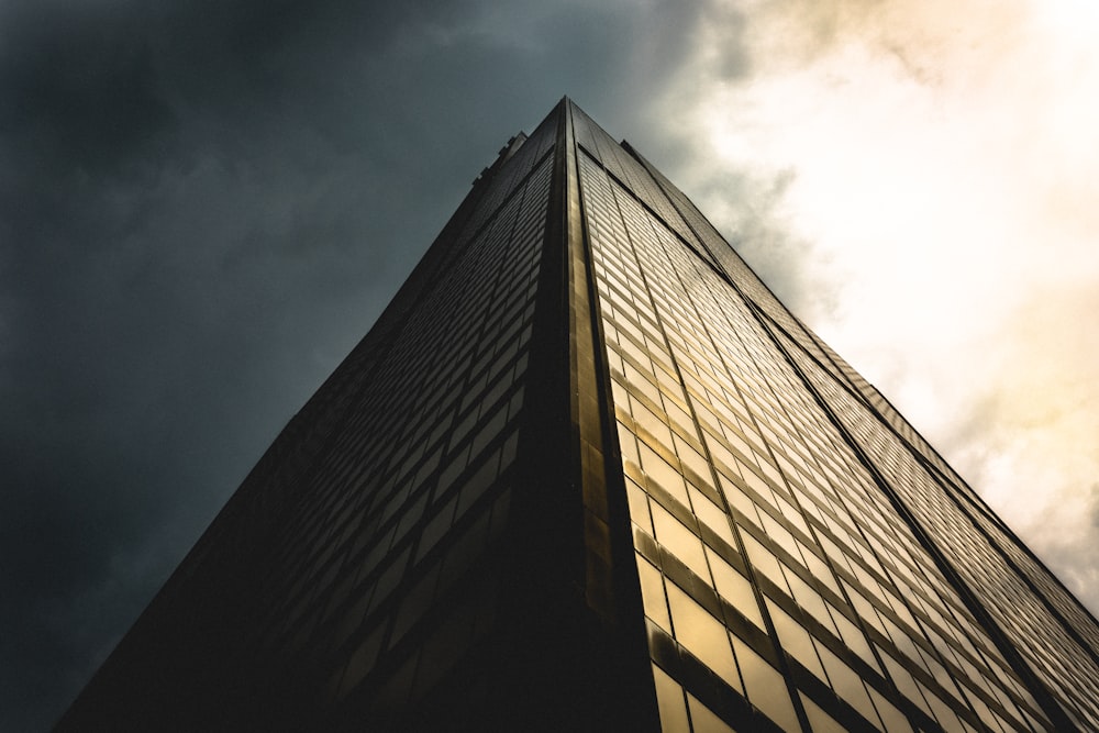 gray sky above black building low angle photography