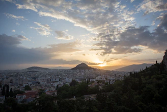 A panoramic view of Kampala city with its rolling hills and Lake Victoria in the background at sunset.