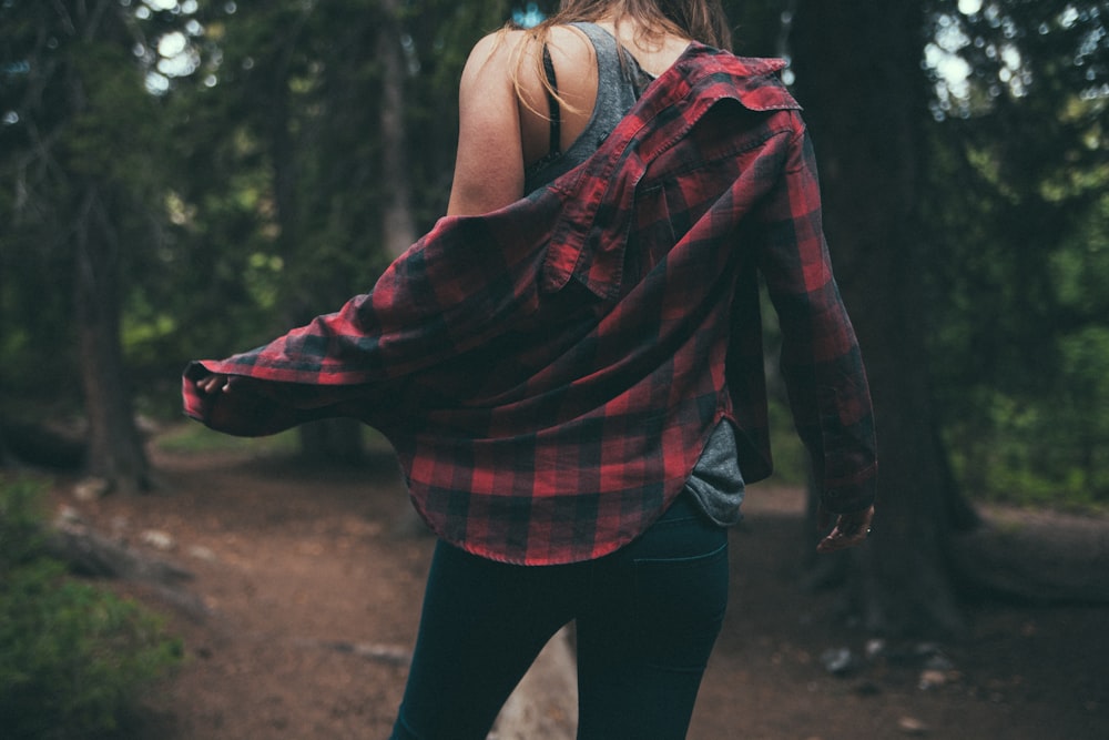 back of person standing between tall trees