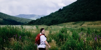 woman wearing red backpack surrounded plants