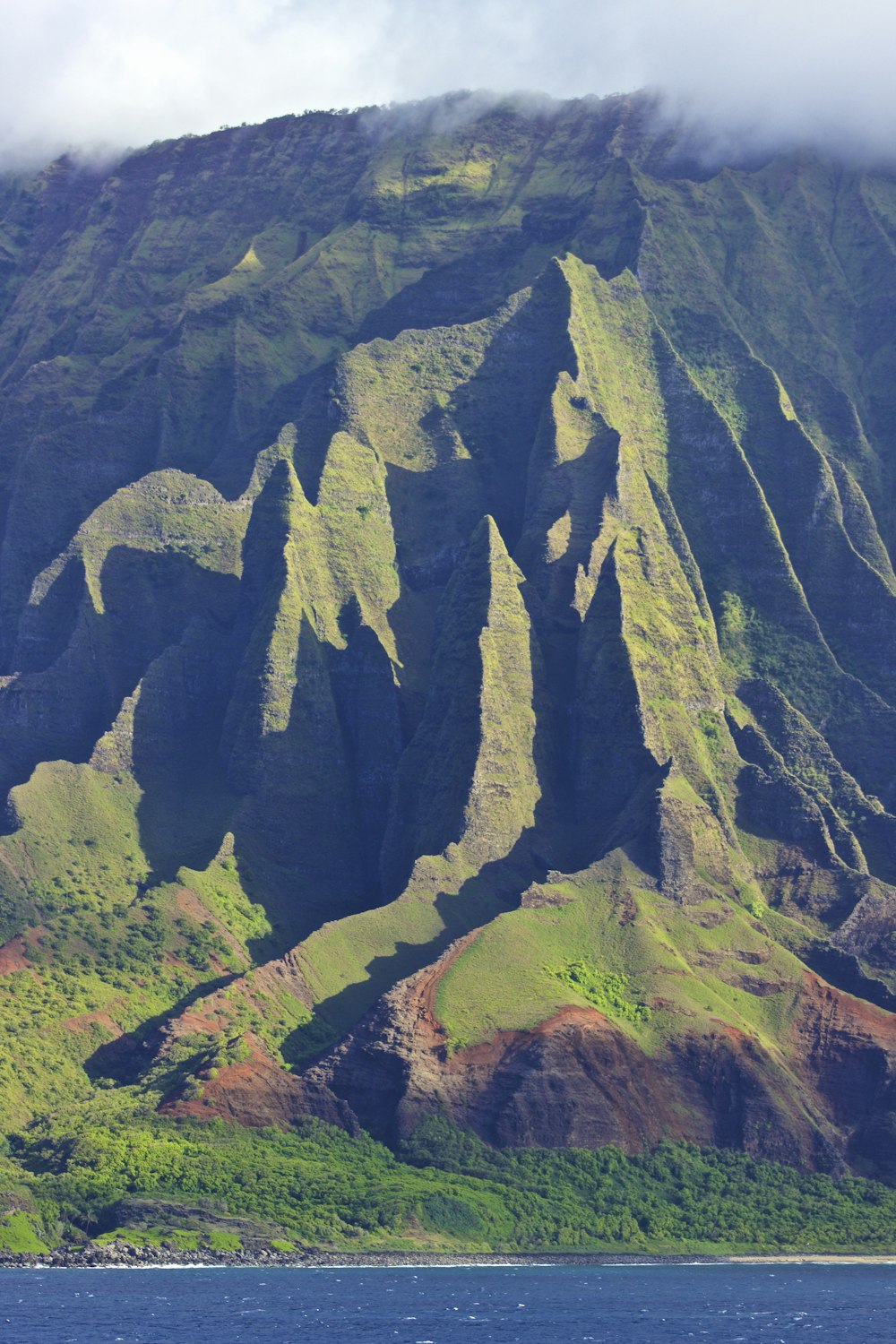 photographie de paysage de montagne verte sous ciel nuageux