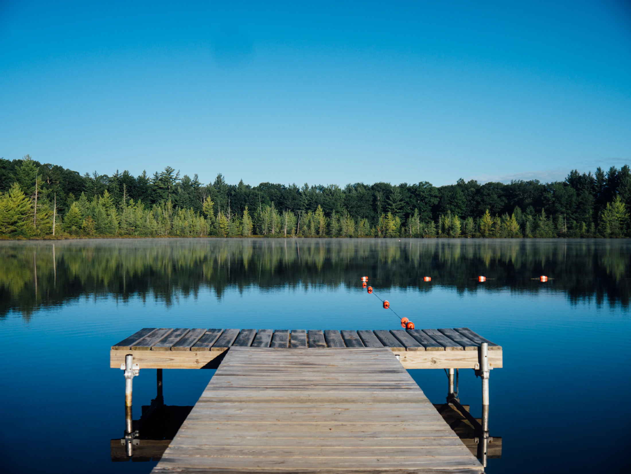Wooden jetty stretching into a calm blue lake