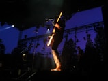 A musician playing guitar on a scenic outdoor stage.