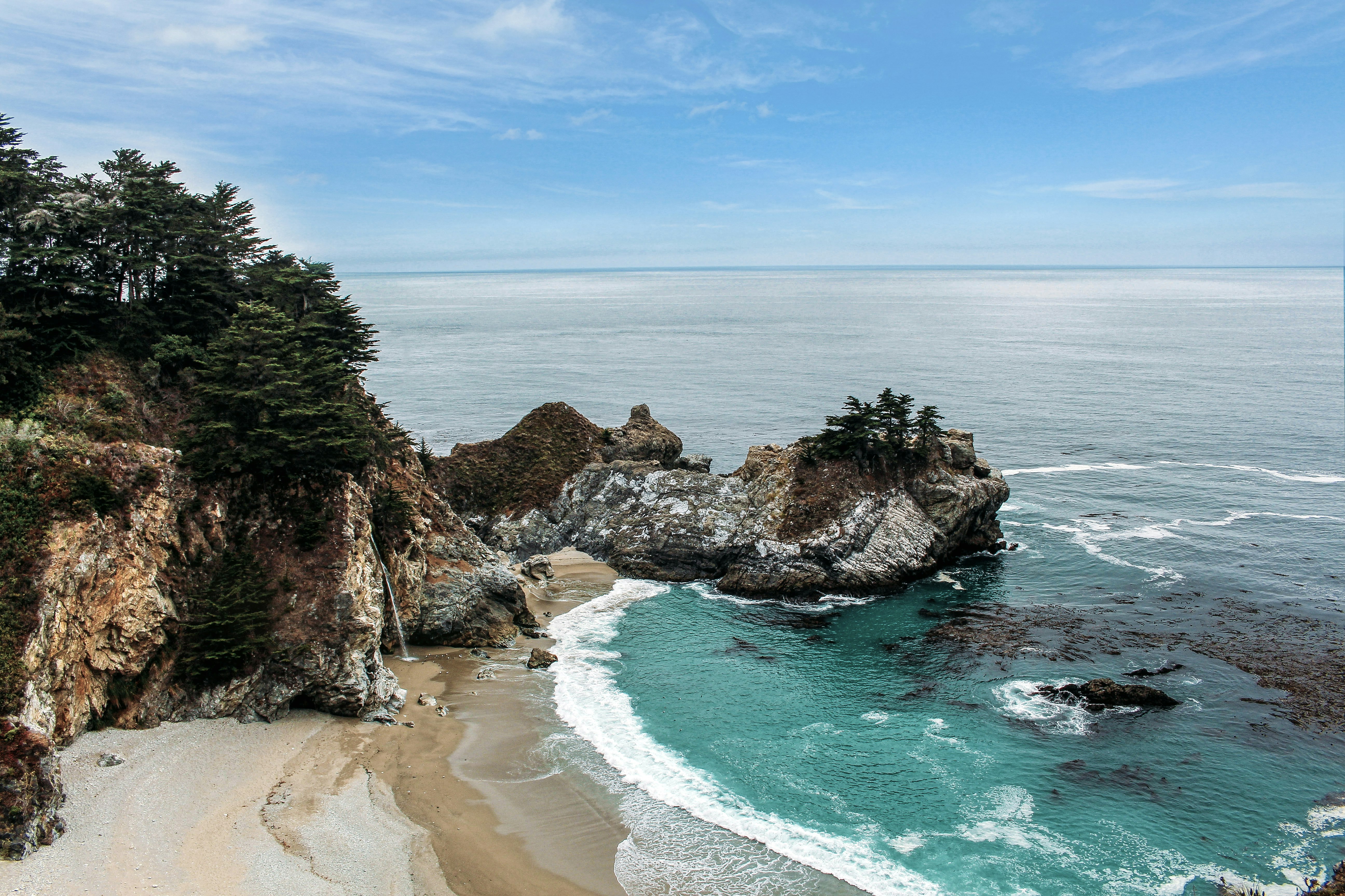 high-angle photo of green sea near white sand beach