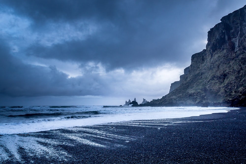 A orillas del mar cerca de las montañas durante el crepúsculo