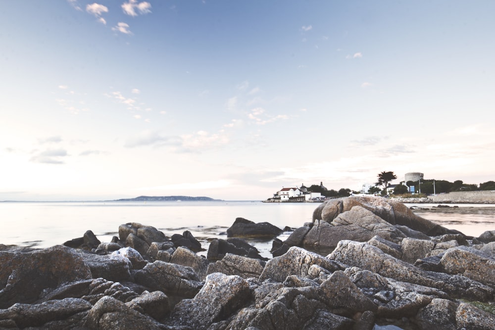 rock formation on seashore under blue sky during daytime