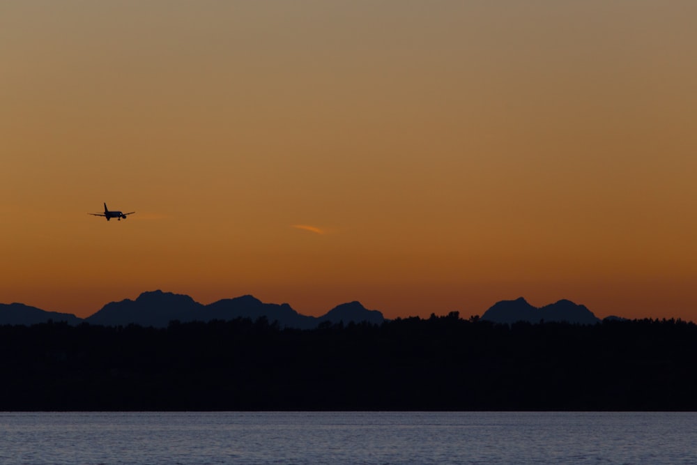 silhouette photo of airplane during sunset