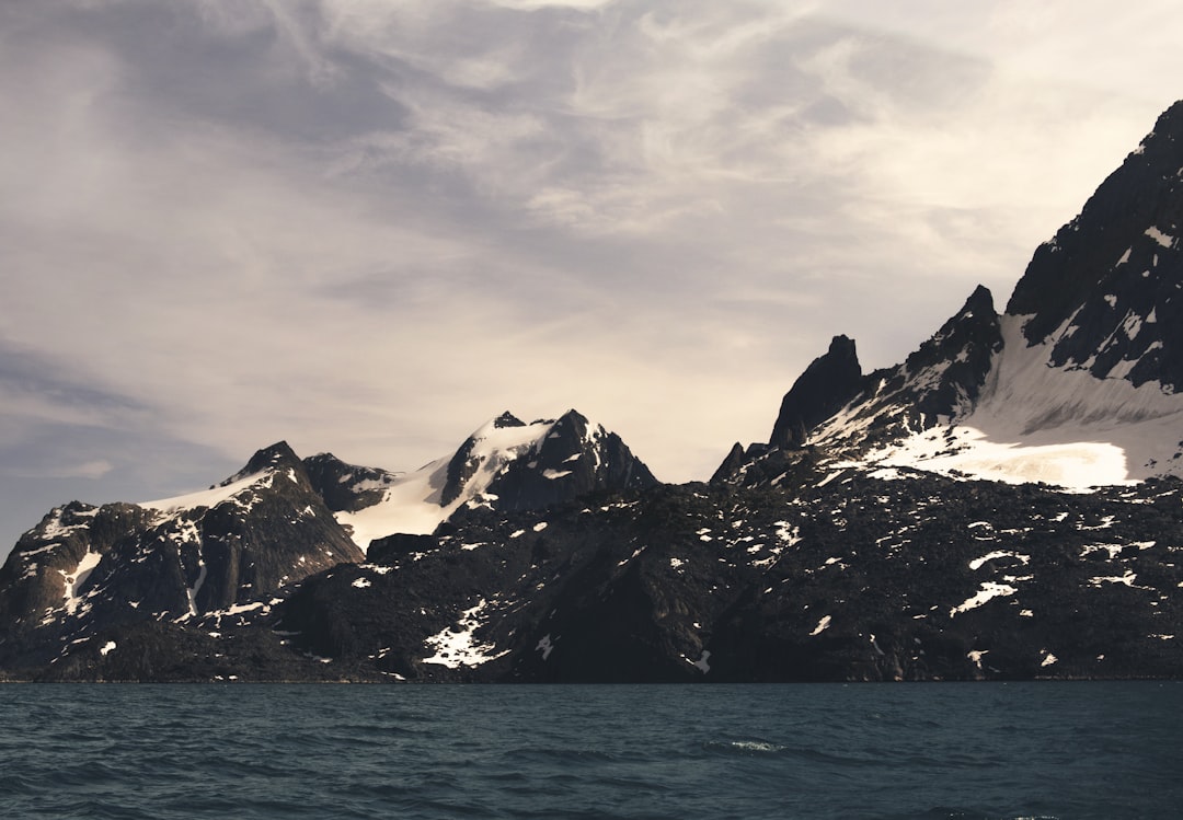 mountain alps near body of water, Snow patch mountains in Greeland