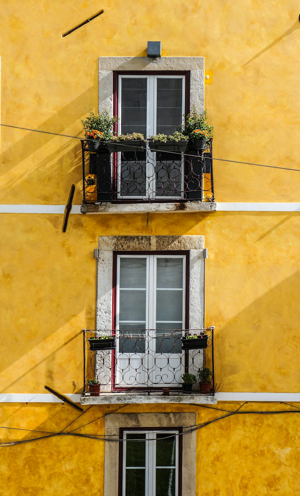 Pannelli per finestre in legno bianco e parete dipinta di giallo
