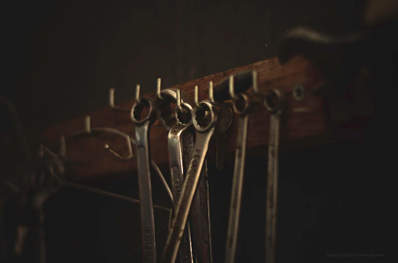 Close-up of a locksmith's hands holding lock picking tools under warm workshop lighting