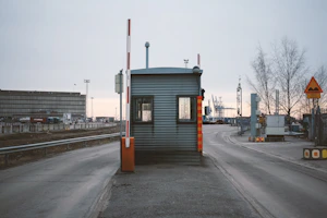 A sturdy black and gold security cabin placed at an industrial site entrance.