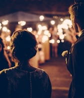 man standing near the woman walking in party during nighttime