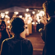 man standing near the woman walking in party during nighttime