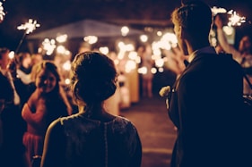 man standing near the woman walking in party during nighttime