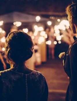 man standing near the woman walking in party during nighttime