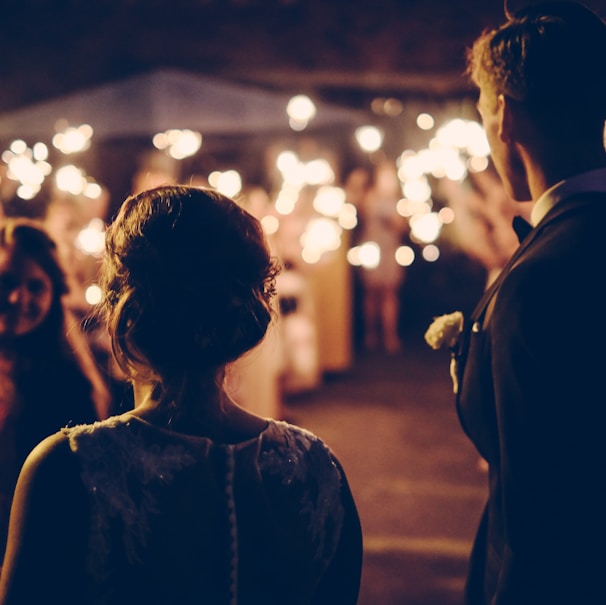 man standing near the woman walking in party during nighttime