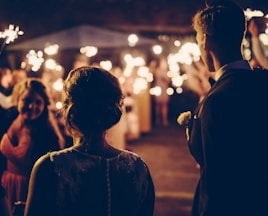 man standing near the woman walking in party during nighttime