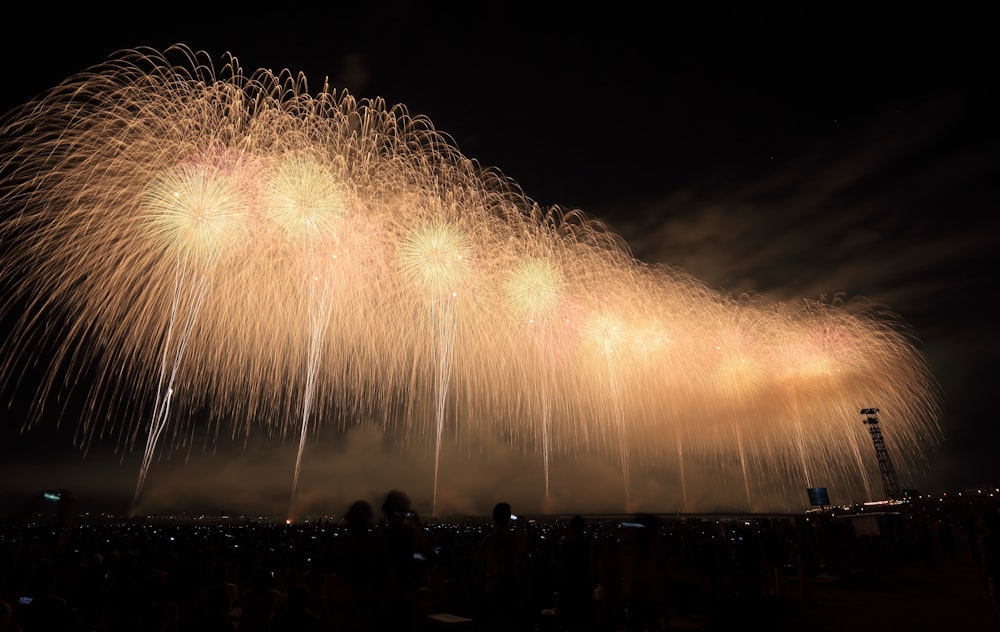 yellow fireworks above a city during night time