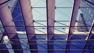 A skilled craftsman installing a sleek aluminium and glass canopy on a modern building exterior.
