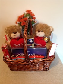 An elegant gift basket filled with plush toys, treats, and a personalized card.