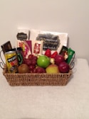 A neatly arranged basket with basic groceries and pharmacy items on a wooden table.