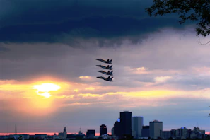 Formation flight of the Darkstar team with the sun setting behind them, casting dramatic silhouettes.