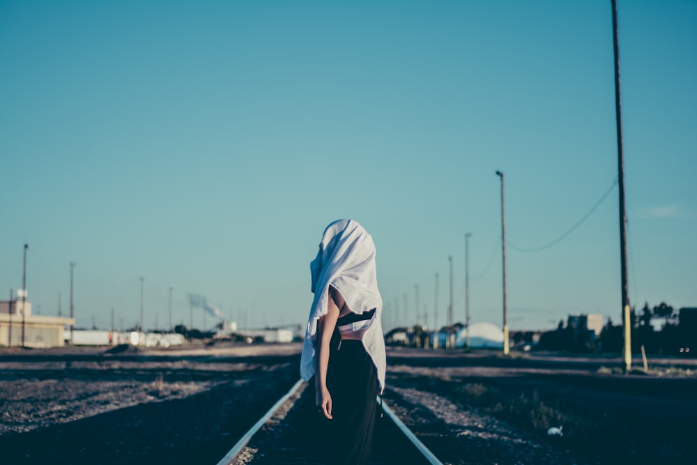 woman standing in the middle of train rail