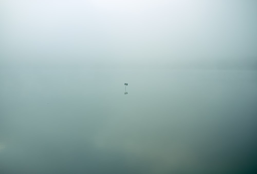 Un seul panneau isolé se trouve dans des eaux calmes étranges couvertes de nuages