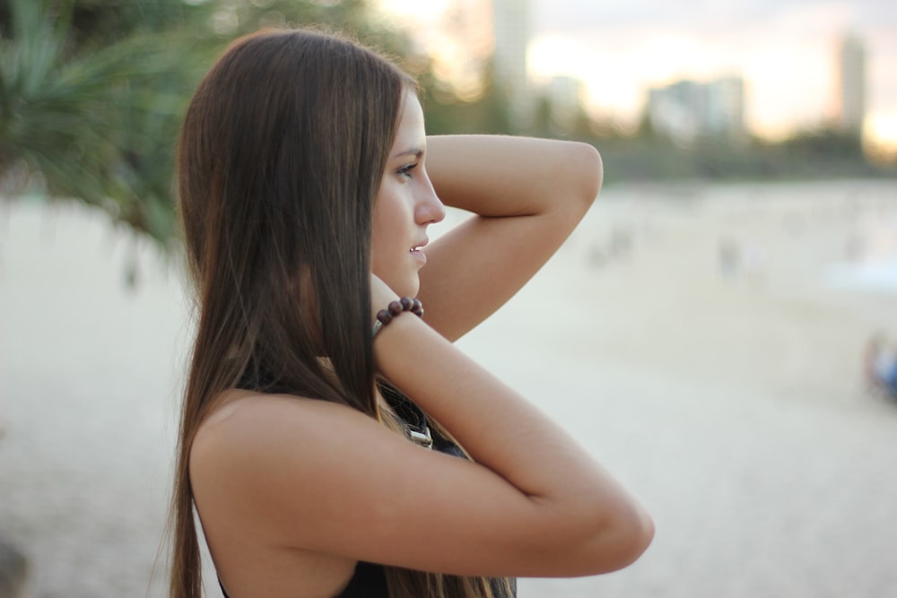 woman at the beach facing the ocean during day