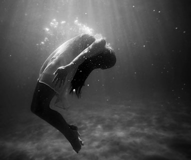 grayscale photo of woman drowning in water