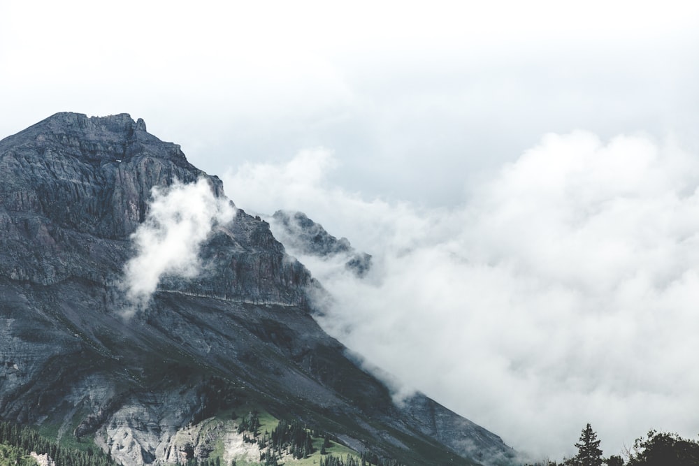 white smoke above gray mountain at daytime