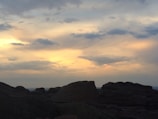 Sunset casting warm orange hues over rocky canyon formations.