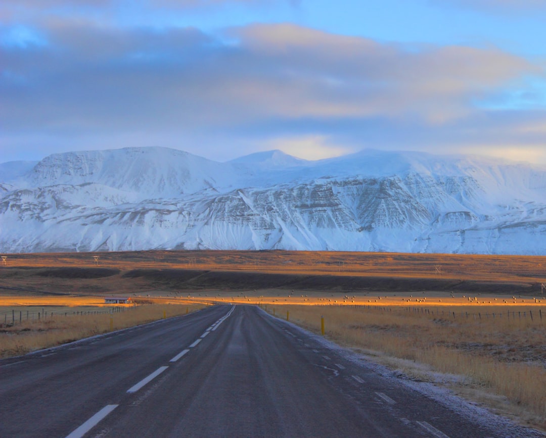 gray asphalt road in front of snow mountains