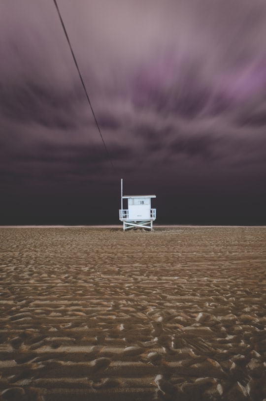 surrealism photo of white house surrounded by sand in Santa Monica United States