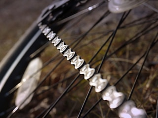 Close-up of bicycle chain being cleaned with a cloth on a sunny day.