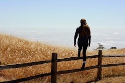 woman jump on brown fence